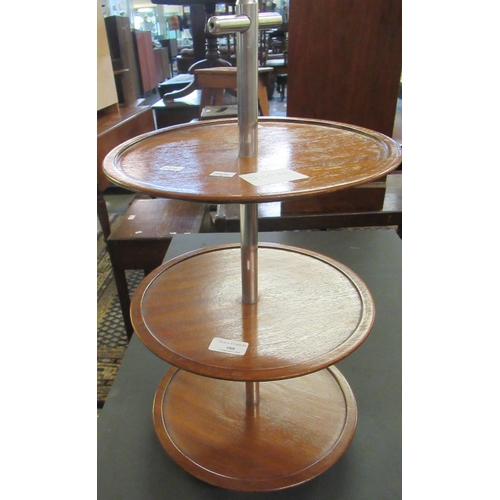 488 - Mid Century mahogany three tier cake stand or dumbwaiter with chrome supports. 
(B.P. 21% + VAT)