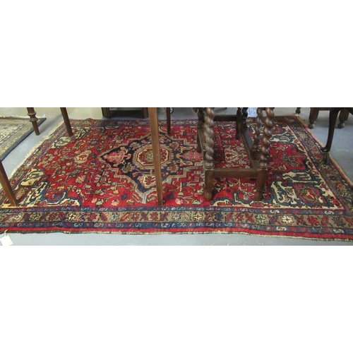 527 - Middle Eastern design red ground carpet with central medallion of flower heads and having geometric ... 