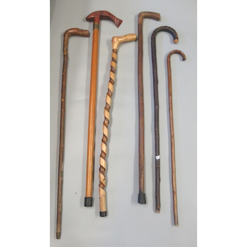 188 - Bundle of six walking sticks to include; spirally turned and a stick with a salmon shaped handle. (6... 