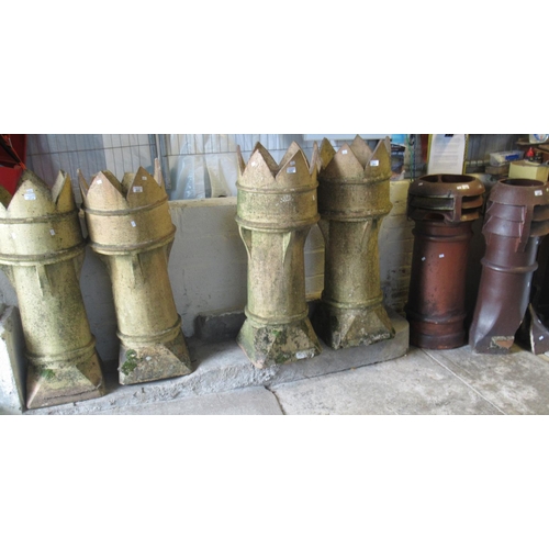 523 - Four similar large castellated terracotta chimney pots. Each approx 110cm high. Together with two st... 