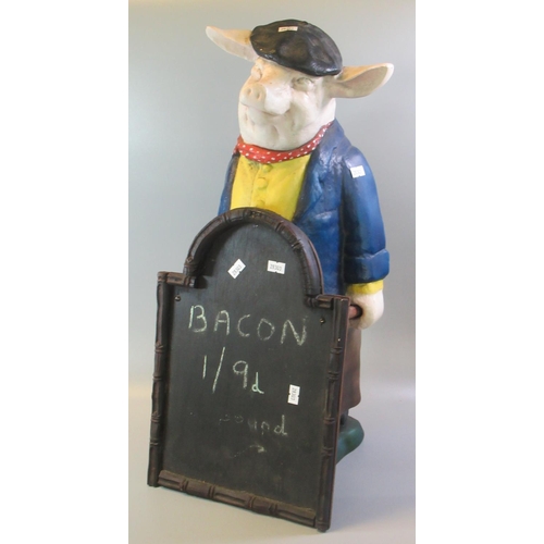 95 - Butchers advertising painted pottery pig holding a board.  56cm high approx.   (B.P. 21% + VAT)