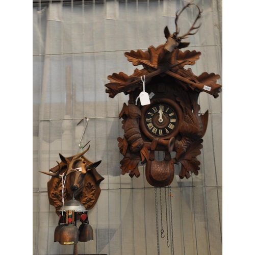 458 - Carved, probably walnut Cuckoo Clock with stags head, animals and rifles on chain with cone waits, t... 