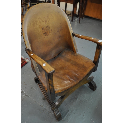 493 - Early 20th century leather back armchair with lion crest, standing on a crinoline base.  (B.P. 21% +... 