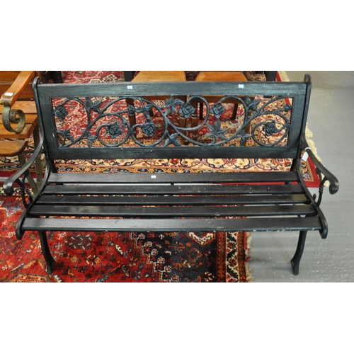 498 - Painted and wooden cast iron two seater garden bench, the back decorated with pierced roses and foli... 