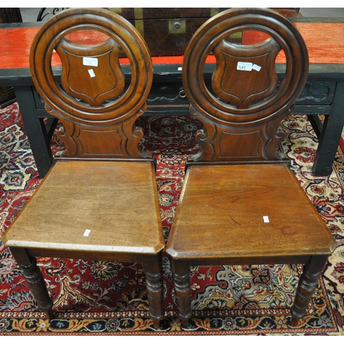 501 - Pair of Victorian mahogany hall chairs, the circular moulded backs inset with carved shield, the mou... 