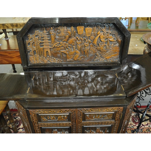 506 - Chinese carved hardwood buffet having hinged lid with carved ornate panels of figures and boats in a... 