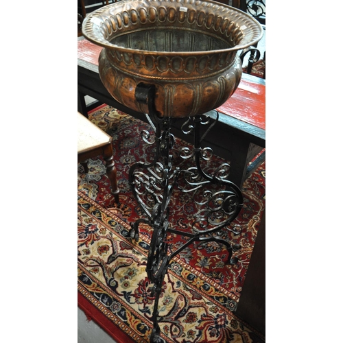 512 - Arts & Crafts design copper and verdigris baluster planter standing on a wrought iron scroll decorat... 