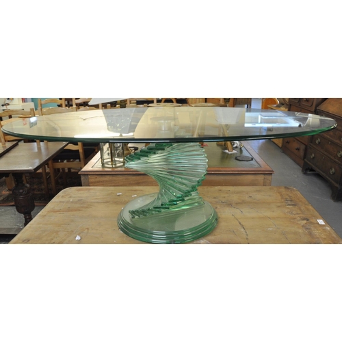 543 - Unusual oval glass coffee table, the base with twisted step design.   (B.P. 21% + VAT)