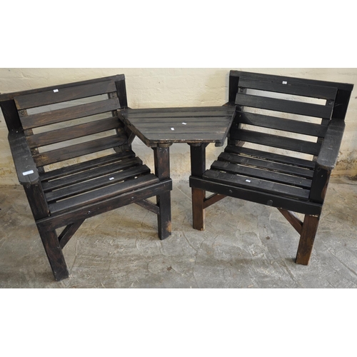 566 - Two modern stained slat back garden chairs with fixed centre table.   (B.P. 21% + VAT)