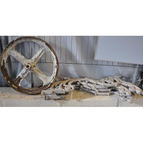 569 - Two pairs of cast iron scroll decorated table/bench ends, together with a cast iron painted wheel.  ... 