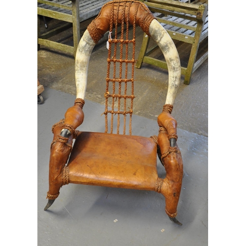 573 - Unusual low armchair, the frame and arms decorated with cows' horns with leather upholstery and rope... 