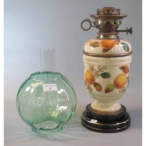 83 - Early 20th Century double oil burner lamp having green glass globular shade, above a ceramic reservo... 