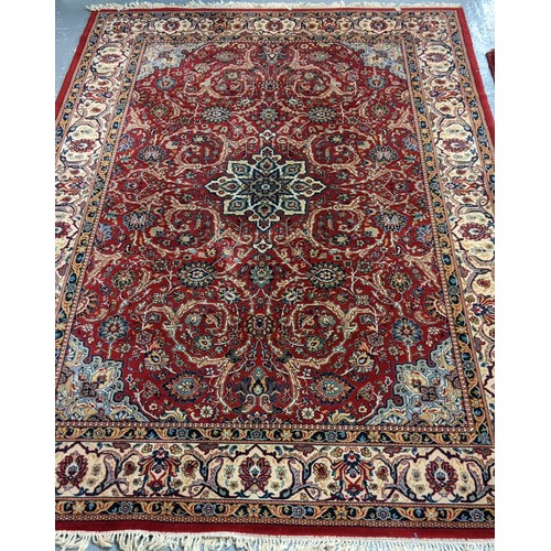 585 - Middle Eastern design red ground carpet decorated with multicoloured flower heads and foliage with g... 