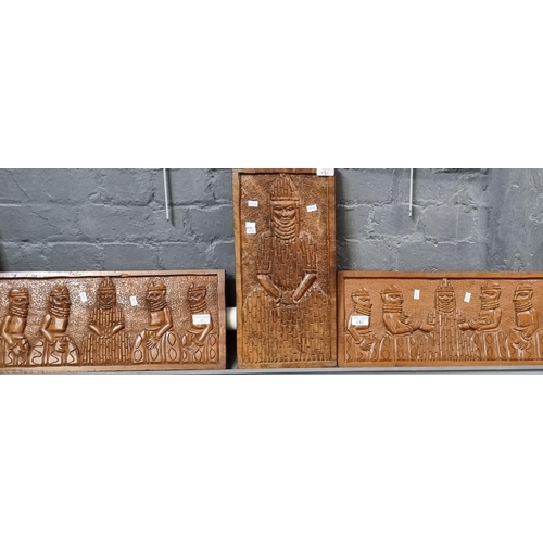 131 - Group of three African carved panels, probably depicting Benin figures.  (3)  (B.P. 21% + VAT)