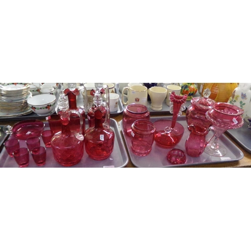 381 - Two trays of cranberry glass items to include: four decanters with stoppers, shot glasses, liqueur g... 