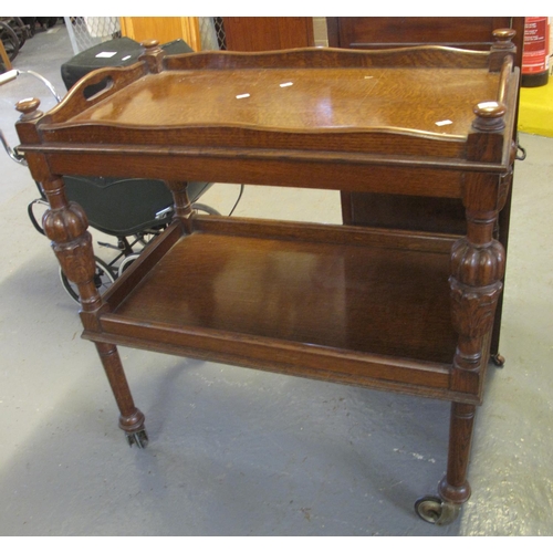 513 - Early 20th century oak tray top two tier trolley on fluted and carved legs, brass cups and wheels.  ... 