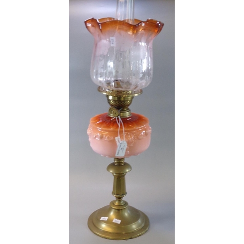 78 - Early 20th Century double oil burner lamp, having clear frosted and orange foliate shade, above an o... 