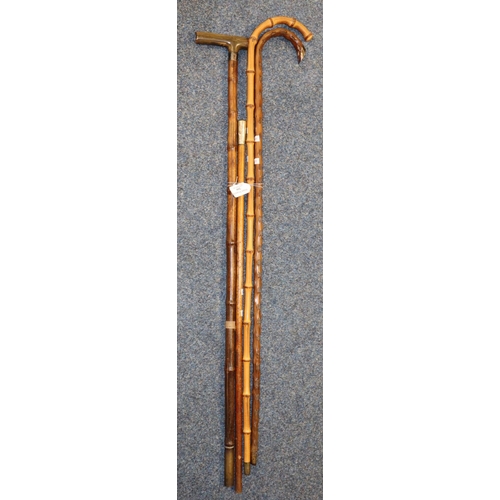 200 - Three bamboo walking sticks/canes, one with horn handle, together with a swagger stick/baton with wh... 