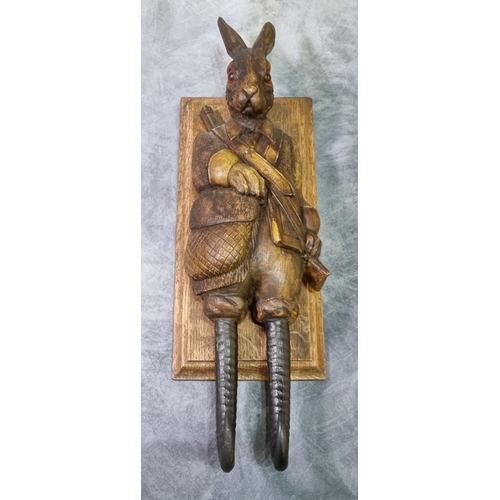 232 - Carved Black Forest style hare coat or game hook, with glass eyes dressed as a huntsman with rifle o... 