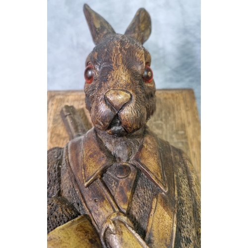 232 - Carved Black Forest style hare coat or game hook, with glass eyes dressed as a huntsman with rifle o... 