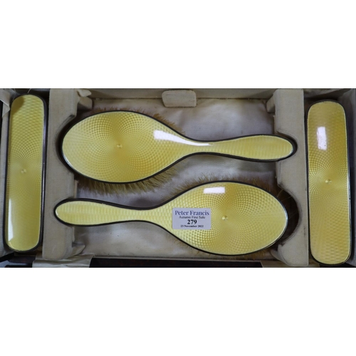 279 - Silver yellow guilloche enamel cased dressing table set comprising: four brushes and a hand mirror, ... 