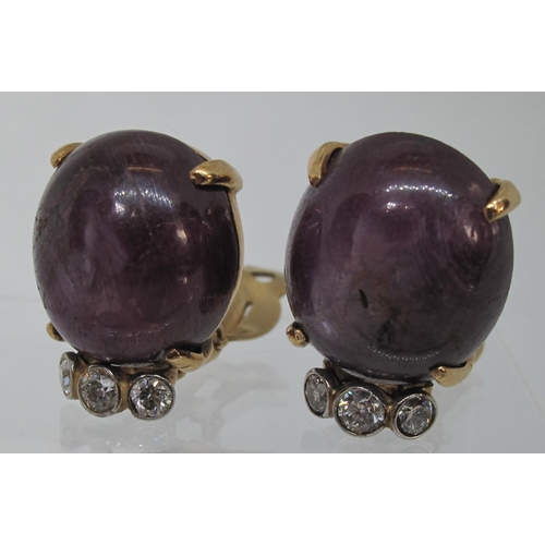 319 - A pair of large synthetic star ruby and diamond earrings set in 14ct gold.  Clip fittings.  Approx w... 