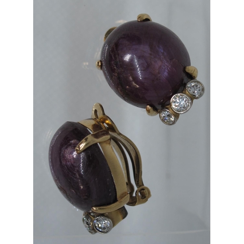 319 - A pair of large synthetic star ruby and diamond earrings set in 14ct gold.  Clip fittings.  Approx w... 