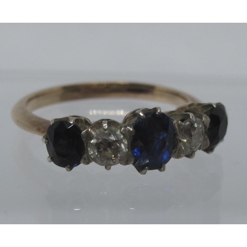 337 - A sapphire and diamond five stone ring set in white metal with a yellow metal band.  Ring size K.  A... 