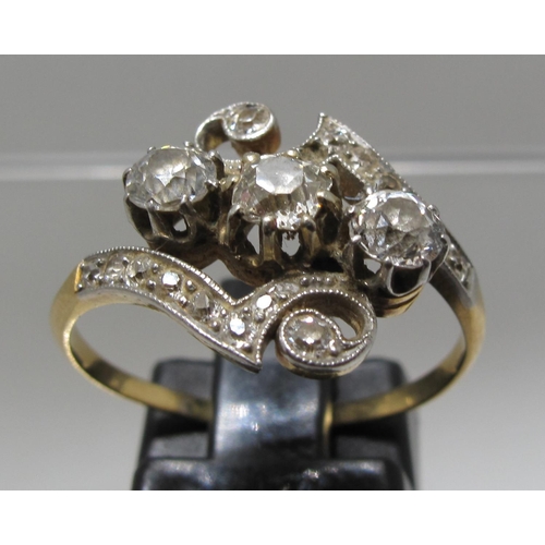 369 - Three stone diamond ring with scrolling design.  Ring size P.  Approx weight 3.5 grams.
(B.P. 21% + ... 