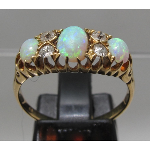 374 - 18ct gold three stone opal ring.  The oval opals separated by diamond points.  Ring size O&1/2.  App... 