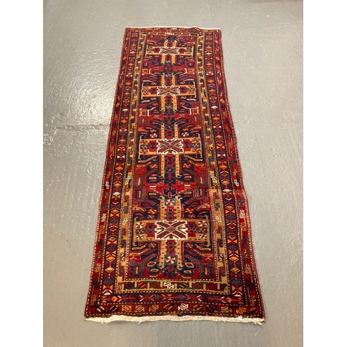 439 - Persian hand woven runner with unique cross door design, on a multi coloured ground.  305x105cm appr... 