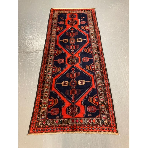 441 - Red and navy ground Hussain runner with double medallion design.  305x125cm approx.  (B.P. 21% + VAT... 