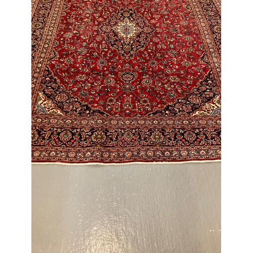 443 - Large red ground Persian Kashan carpet with traditional Kashan medallion design, flowers and foliage... 