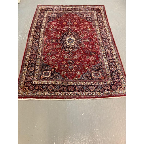 444 - Vintage red ground Persian Mashad carpet with traditional floral medallion design.  276x192cm approx... 