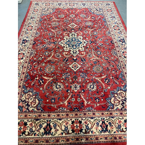 448 - Terracotta ground Persian Sarouk carpet with traditional floral medallion design.  334x225cm approx.... 