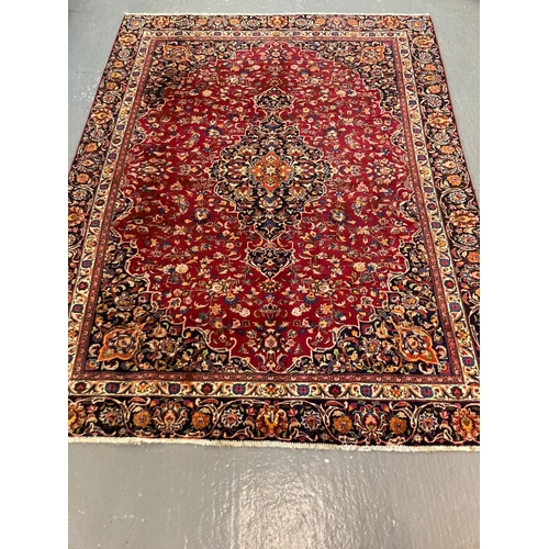 450 - Red ground Persian Mashad carpet with floral medallion design.  295x223cm approx.