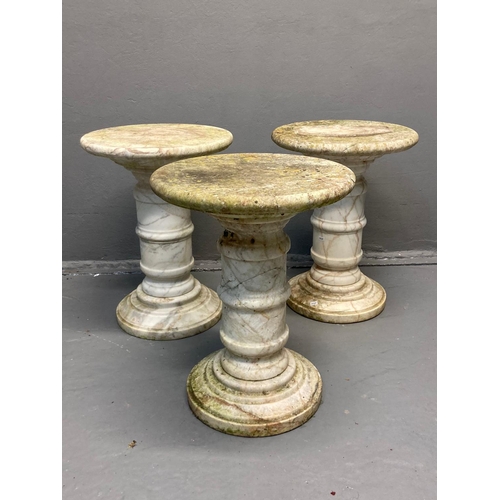 455 - Three similar marble torchere stands, the moulded circular tops standing on a  
stepped circular ped... 