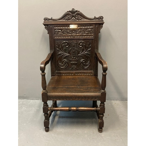 60 - Early 20th Century carved and stained oak Eisteddfod chair, the carved back with dolphin, vase and f... 