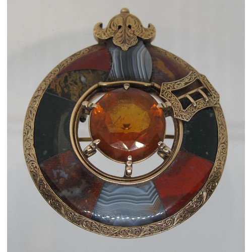 388 - A Victorian Scottish pebble brooch set in yellow metal with agate stones and to the centre with a ca... 