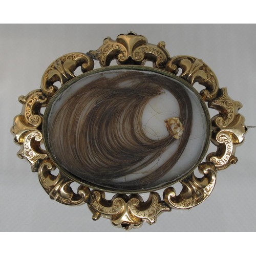 401 - A Victorian yellow metal mourning brooch with central locket section containing a curl of hair withi... 