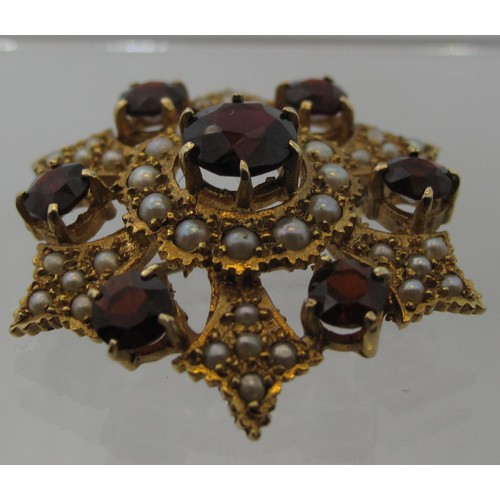 402 - A 9ct gold garnet and seed pearl brooch.  Approx weight 8.3 grams.
(B.P. 21% + VAT)