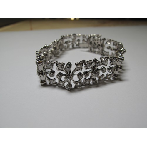 321 - Diamond openwork bracelet of hinged square links with hinged integral clasp.  Set in unmarked white ... 