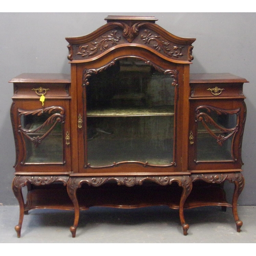 13 - Edwardian mahogany display cabinet, overall ornately carved and having three glass doors. The interi... 