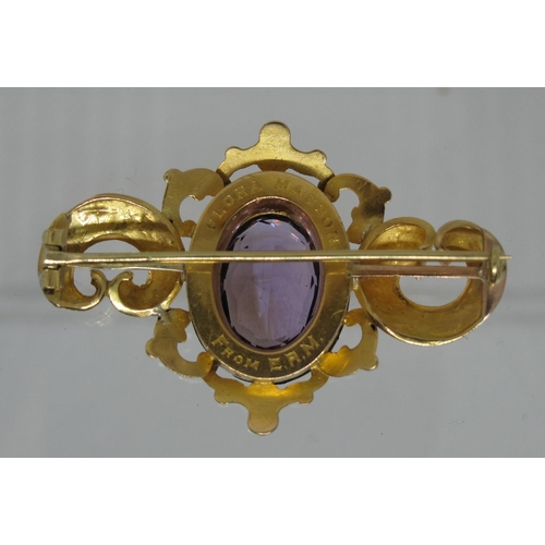 357 - A late Victorian yellow metal brooch decorated with scrolling foliate engraving highlighted with pal... 