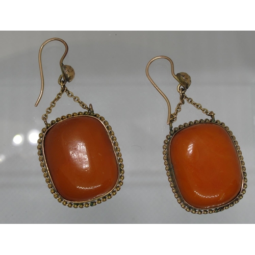 408 - A pair of butterscotch amber drop earrings set in yellow metal.  Length of drop 3.5cm. Approx weight... 