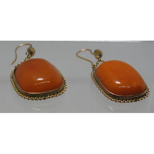 408 - A pair of butterscotch amber drop earrings set in yellow metal.  Length of drop 3.5cm. Approx weight... 