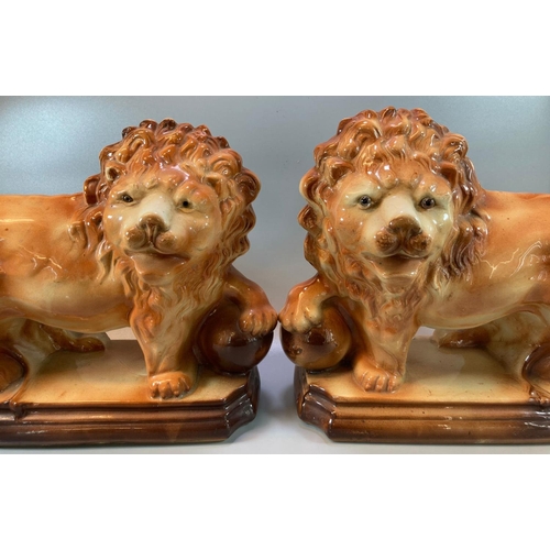 187 - Pair of early 20th Century Staffordshire pottery fireside lions with glass eyes, standing on balls. ... 