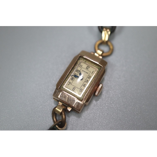 423 - Lady's small 9ct gold faced Renown wristwatch of rectangular form with leather strap.
(B.P. 21% + VA... 