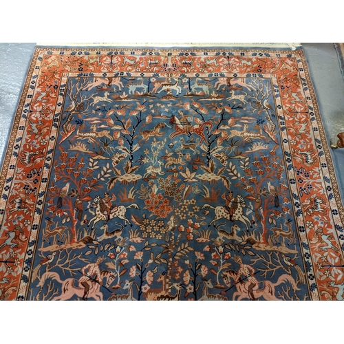 714 - Chinese Persian style blue ground rug, overall decorated with animals, birds and hunting scenes, wit... 