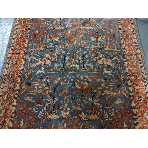 714 - Chinese Persian style blue ground rug, overall decorated with animals, birds and hunting scenes, wit... 